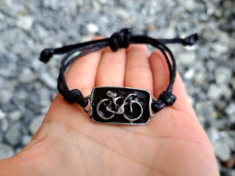 Bransoletka z rowerem ( w odcieniu ciemnego srebra, na czarnym sznurku)