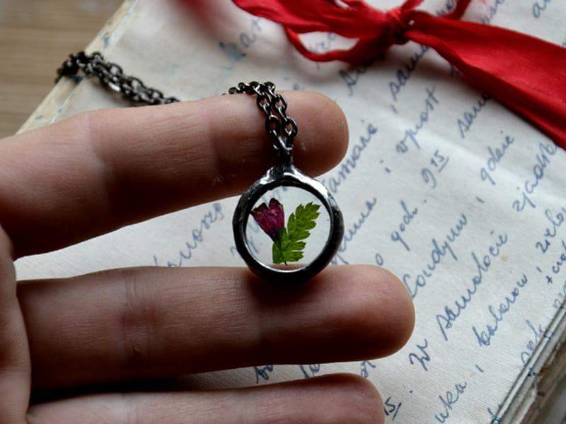 Drobny naszyjnik z paprocią i dzwonkiem (oprawa w kolorze ciemnego srebra)