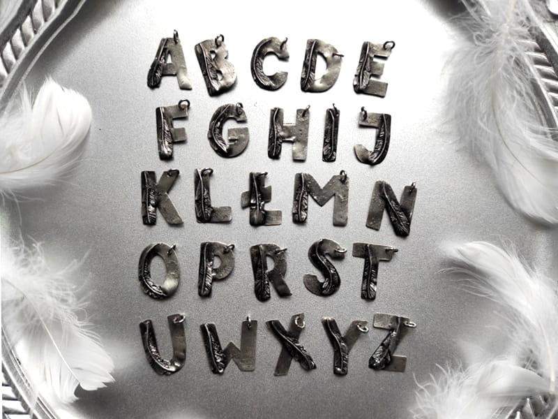 Naszyjnik literka z piórkiem (na łańcuszku ze stali chirurgicznej)