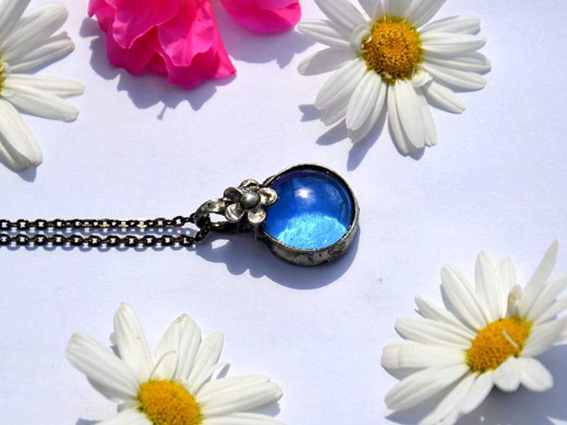 Naszyjnik z błękitnym szkiełkiem i kwiatuszkiem (oprawa w kolorze ciemnego srebra)