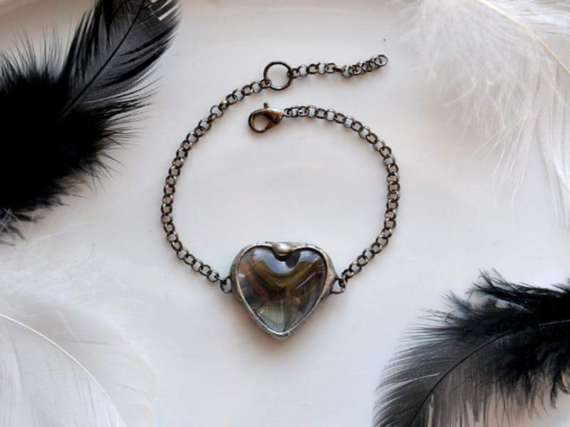 Nostalgiczna bransoletka z czarnym piórkiem w sercu (oprawa w kolorze ciemnego srebra)
