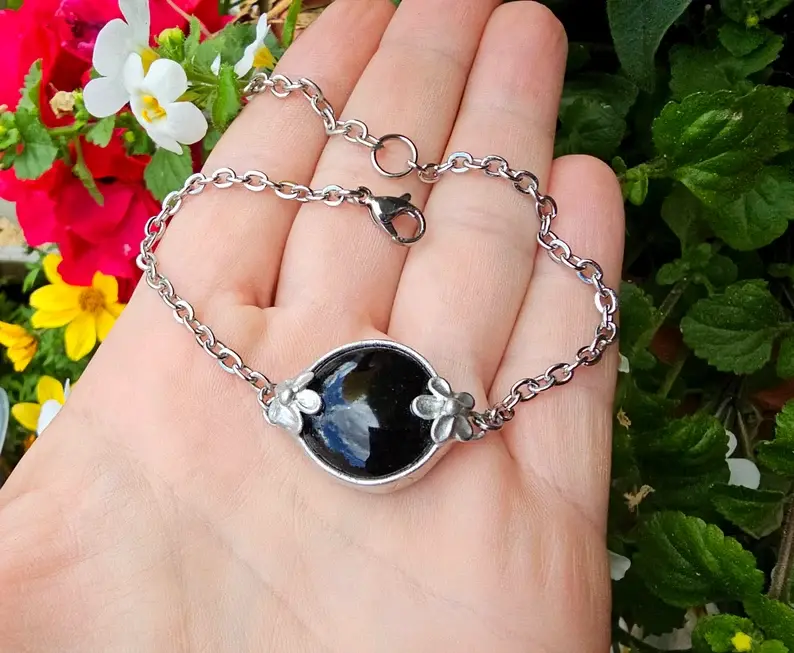 Romantyczna bransoletka z czarnym szkiełkiem i kwiatkiem (oprawa w kolorze srebrnym)