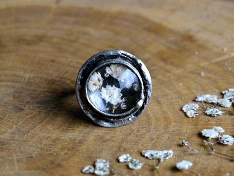 Rustykalny pierścionek z białymi kwiatuszkami na ciemnym tle (w kolorze ciemnego srebra)